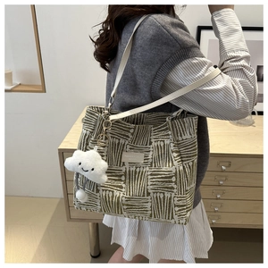 Detail of striped fabric tote bag with white leather strap and plush cloud charm