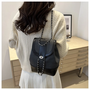 Detail of black PU leather backpack with silver rotating buckle and metal chain strap