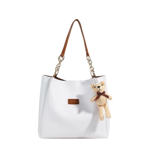 White minimalist leather tote bag with brown handles and a stylish gold chain detail