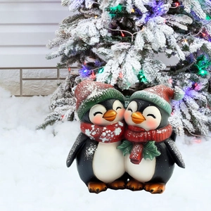 Close-up of cute Christmas penguin figurines in red scarves on a snowy background