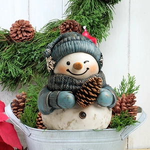 Scultura dettagliata di pupazzo di neve di Natale con cappello blu e pigna in un secchio