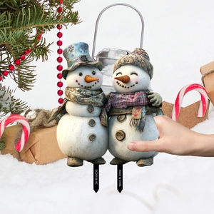 Dettaglio di paletti da giardino con pupazzo di neve retrò, cappelli vintage e sciarpe a quadri