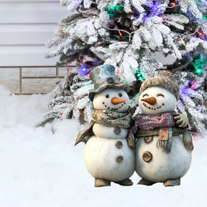 Dettaglio di una coppia di pupazzi di neve con sciarpe festive in un giardino innevato