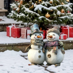 Dettaglio di figurine di pupazzi di neve in resina con sciarpe in un giardino innevato