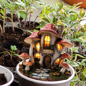 Detail of mushroom house garden stake with glowing windows and Welcome sign