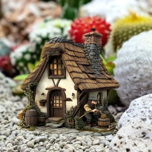 Macro shot of miniature garden house with thatch roof and gnome figure ornament