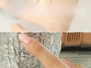 Detail of nude pink glossy oval press-on nails with a natural crystal finish on finger