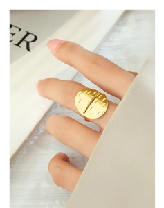 Macro detail of a gold oval adjustable ring with geometric texture and industrial design