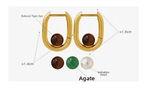 Détail de boucles d'oreilles en U dorées avec perles interchangeables en agate