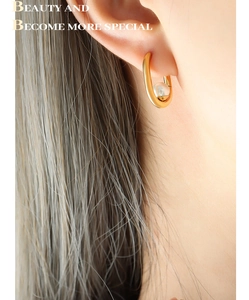 Vue détaillée de la boucle d'oreille en U plaquée or avec perle portée par un mannequin