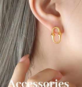 Gros plan de boucles d'oreilles ovales dorées géométriques portées par un mannequin