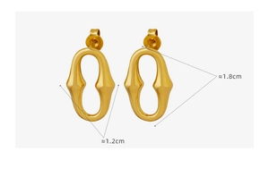 Détail macro de boucles d'oreilles ovales dorées en U mesurant 1,8 cm par 1,2 cm