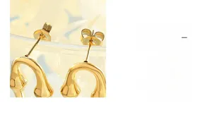 Vue détaillée de boucles d'oreilles en forme de U dorées avec finition polie