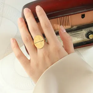 Minimalist gold oval open ring with brushed texture finish on a vintage background