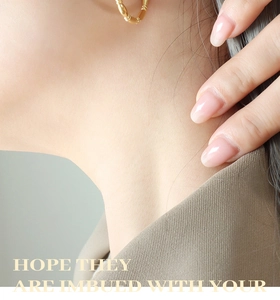 Detail of gold bamboo texture hoop earrings worn by a model for a trendy look