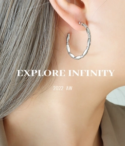 Detailed view of silver bamboo-style C-shaped hoop earrings on female model