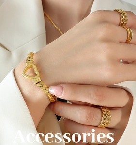 Detail showing gold-plated chunky chain bracelet with heart charm and matching rings set