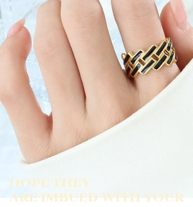 Gros plan d'une bague croisée en or 18 carats avec détails en émail noir rectangulaire