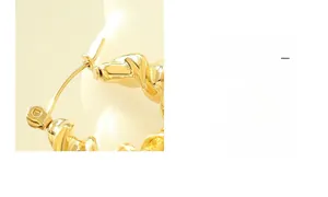 Detailed macro view of twisted C-shaped earrings with high-polish 18K gold finish