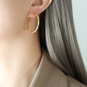 Elegant gold bamboo joint C-shape hoop earrings in titanium steel worn by model