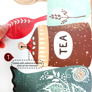 Detail showing hand peeling a removable kitchen wall sticker with tea pot and spoon patterns