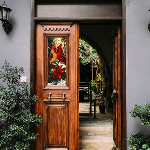 Detail of Christmas cardinal birds and poinsettia glass stickers on a wooden door