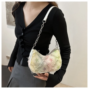 Detail of star pattern crescent shoulder bag with vintage frayed edges and chain strap