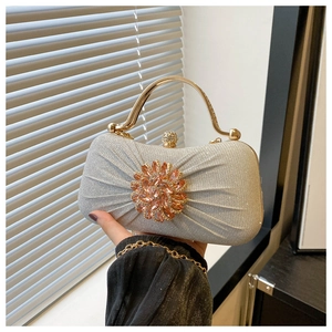 Détail de la pochette de soirée plissée argentée avec fleur en cristal et fermoir doré