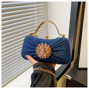 Détail de la pochette de soirée à paillettes bleues avec fleur en cristal étincelant