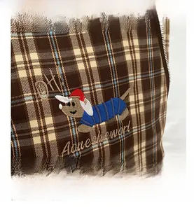 Detailed close-up of British style checkered tote bag with cartoon dog embroidery