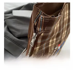Macro detail of high-quality metal zipper and vintage plaid fabric with brown piping