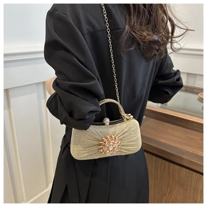 Détail de la pochette de soirée à paillettes dorées avec fermoir fleur en strass étincelant