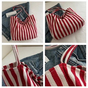 Detail shot of red and white striped canvas tote bag showing thick fabric and strap texture