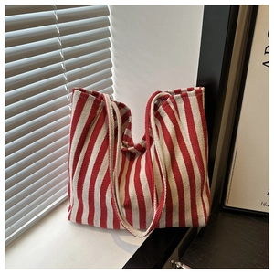 Detailed close-up of red and white vertical striped canvas tote bag in soft natural light