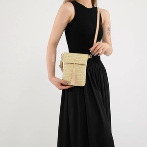 Vintage woven straw crossbody bag with leather flap and tassel on black dress