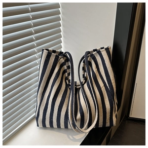 Detail of blue and beige striped canvas tote bag resting on a sunny windowsill