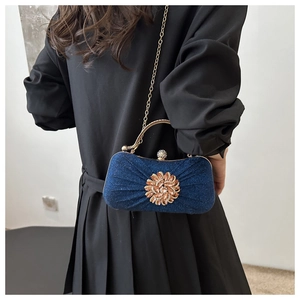 Détail de la pochette de soirée plissée bleu marine avec texture scintillante et strass