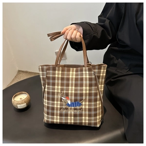 Detail of embroidered dachshund motif on checkered canvas tote bag with leather handles