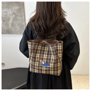 Detail of vintage plaid tote bag with embroidered dachshund and brown shoulder straps
