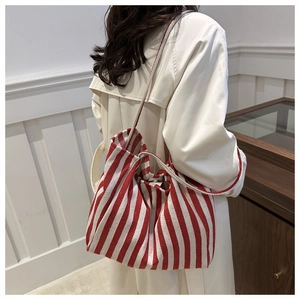 Red and white striped canvas tote bag styled with a white outfit for casual daily look