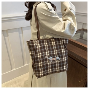 Detail of checkered tote bag featuring embroidered dachshund and side zipper accents