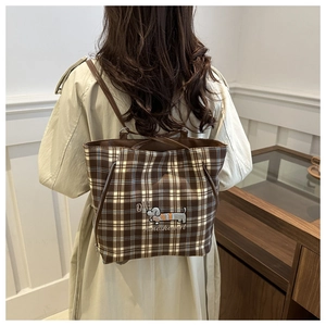 Detail of checkered tote backpack showing dachshund embroidery and slim leather straps