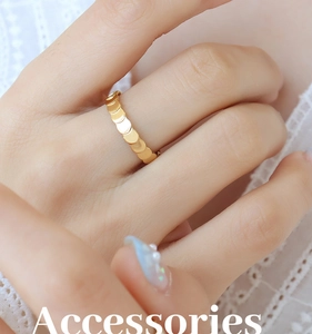 Detailed close-up of a gold-plated layered scale texture ring worn on a finger
