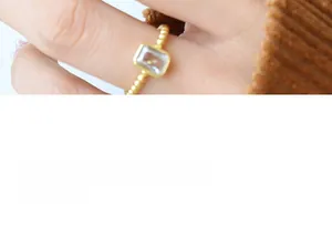 Detail of vintage brass ring featuring a rectangular zircon and textured beaded band