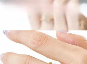 Detail of a minimalist gold ring with metallic beads on a female hand model