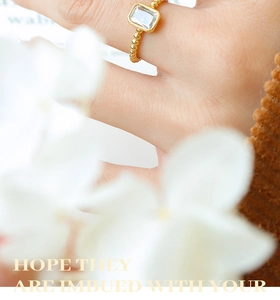 Detail of a vintage brass ring featuring a square zircon and beaded texture band
