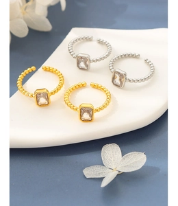 Detailed shot of gold and silver copper rings with square zircon and beaded band