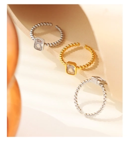 Detailed view of beaded band rings with emerald cut cubic zirconia in gold and silver finish