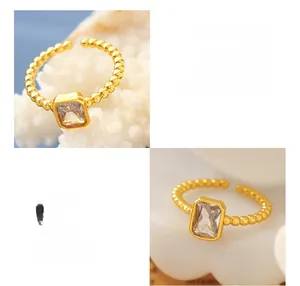 Macro detail of brass ring featuring a large square zircon and beaded texture band