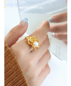 Detailed close-up of a gold-plated irregular lava pearl ring worn on the finger